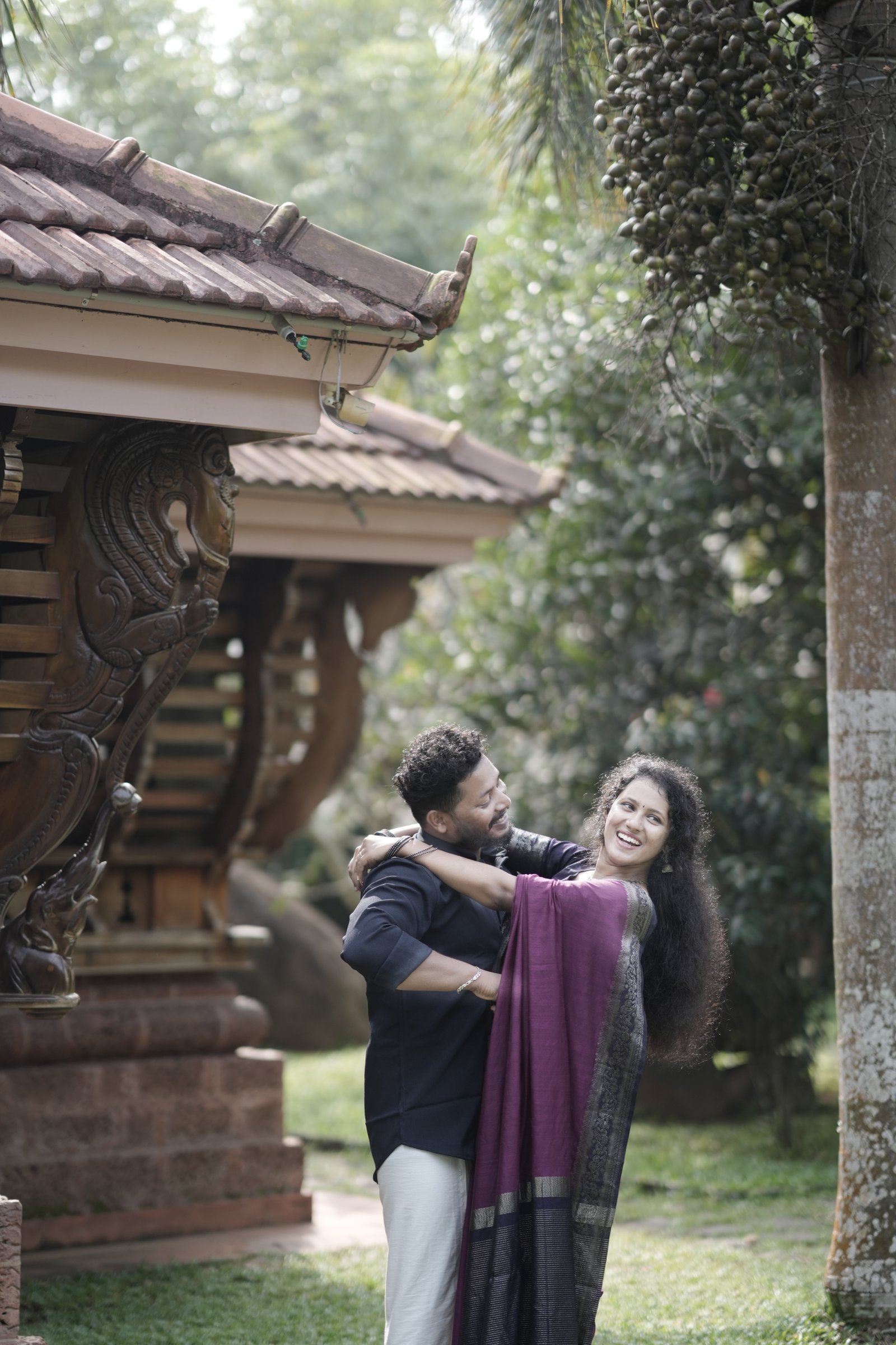 Rahul and Sruthy laughing and embracing joyfully outdoors